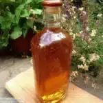 Sirop de thym maison dans une bouteille en verre sur fond de bois
